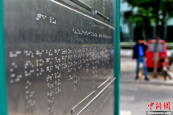 5月25日，北京市西直門公交車站臺上，一座用盲文“書寫”站點的不銹鋼盲文公交站牌悄然建成。在站牌下方圍繞站牌鋪設(shè)的盲人步道與站牌的結(jié)合方便了盲人的乘車出行。中新網(wǎng)記者